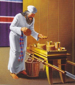 A priest changes out the bread at the Table of Showbread in the Tabernacle of Moses.